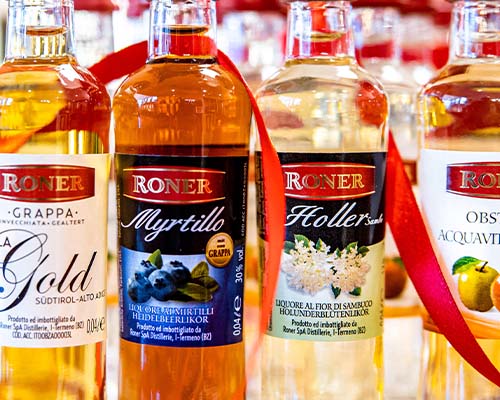 Roner kleine Flaschen nebeneinander Grappa, Myrtillo, Holler mit rotem Band